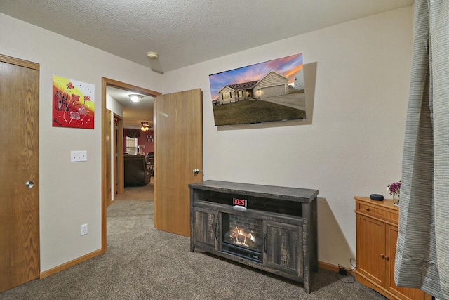 hallway featuring a textured ceiling, baseboards, and carpet