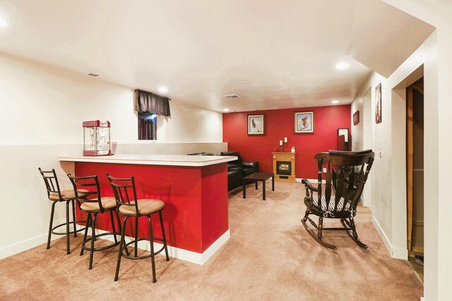 bar featuring recessed lighting, baseboards, light carpet, and a bar