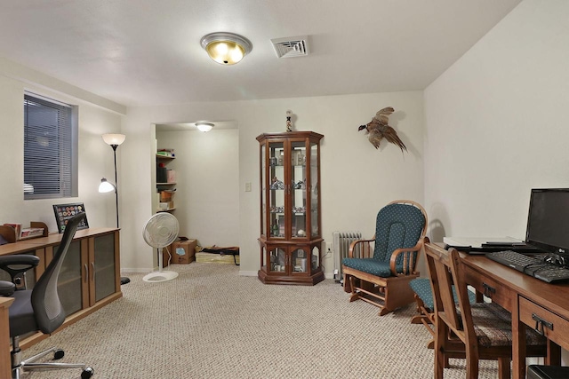 carpeted home office with radiator, baseboards, and visible vents