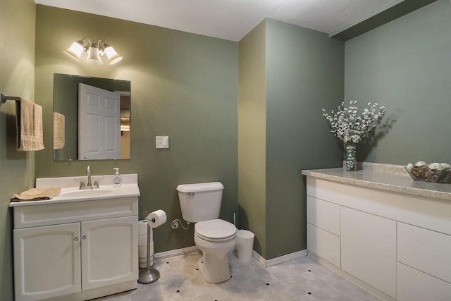 bathroom with baseboards, vanity, and toilet