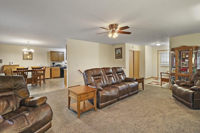 living room with light colored carpet and ceiling fan with notable chandelier