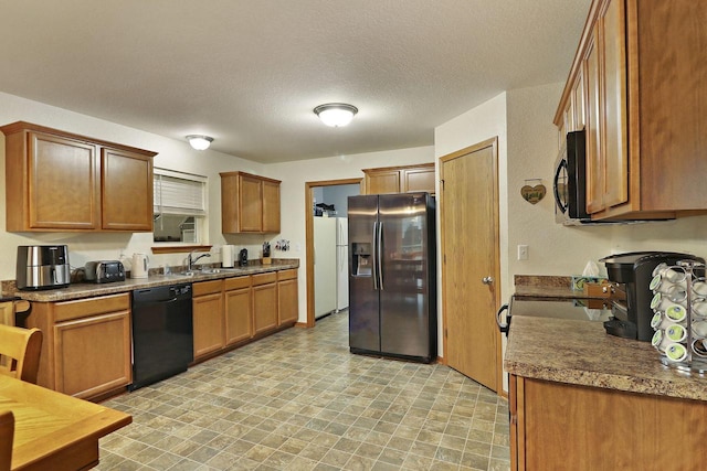 kitchen featuring a sink, black appliances, brown cabinets, and a textured ceiling