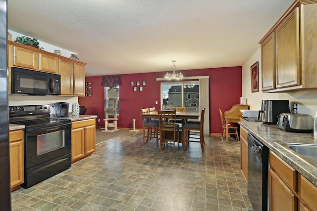 kitchen with brown cabinetry, a notable chandelier, and black appliances