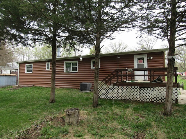 back of house featuring a lawn, a deck, central AC, and faux log siding