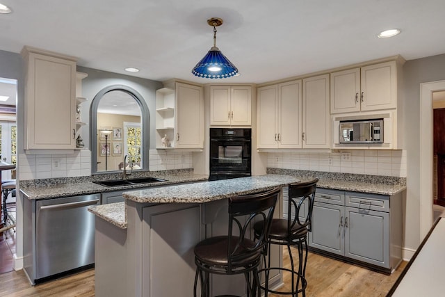kitchen with a sink, stainless steel appliances, open shelves, recessed lighting, and light wood finished floors