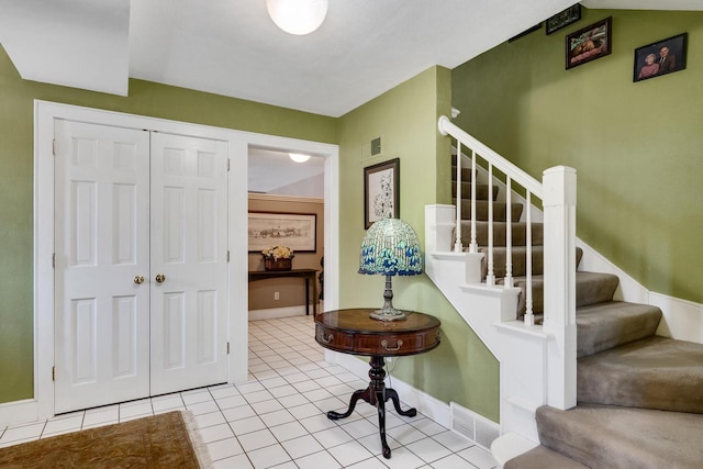stairs featuring baseboards, tile patterned floors, and visible vents
