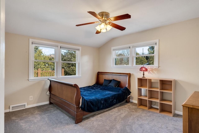 carpeted bedroom with lofted ceiling, ceiling fan, baseboards, and visible vents