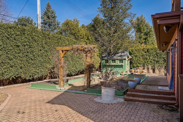 view of patio featuring an outbuilding and a garden