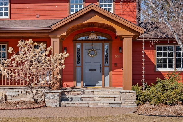 entrance to property with roof with shingles
