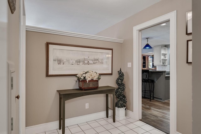 corridor featuring baseboards and tile patterned floors