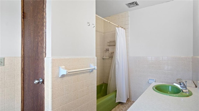 1413 E Clairemont Ave, Eau Claire, WI 54701 - bathroom with a sink, tile walls, a wainscoted wall, and visible vents
