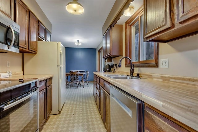 E5081 865th St, Boyceville, WI 54725 - kitchen featuring a sink, brown cabinetry, stainless steel appliances, and light countertops