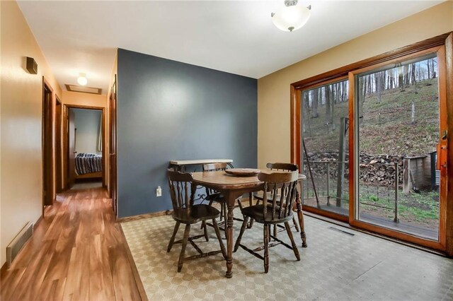 E5081 865th St, Boyceville, WI 54725 - dining area with attic access, baseboards, visible vents, and wood finished floors