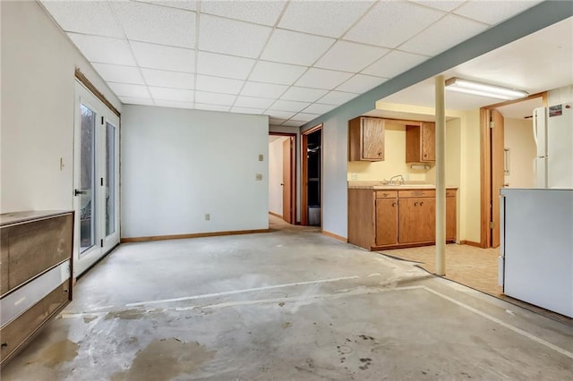 E5081 865th St, Boyceville, WI 54725 - unfurnished living room with a drop ceiling, unfinished concrete floors, baseboards, and a sink