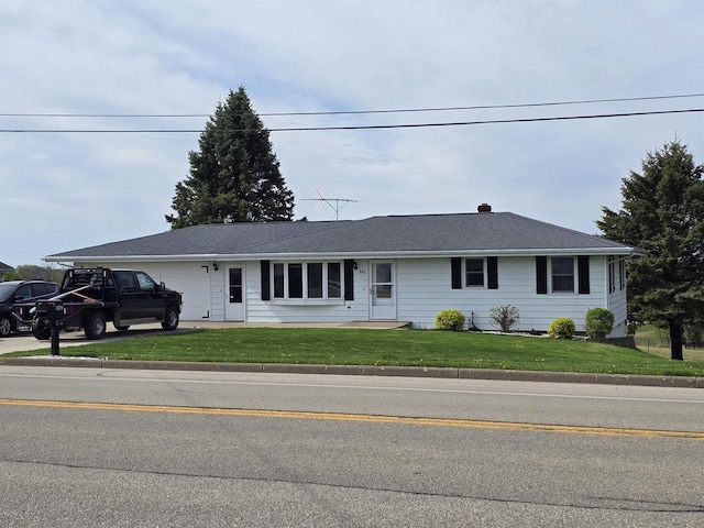 ranch-style house featuring a garage and a front lawn