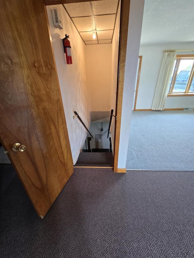 staircase featuring carpet floors, baseboards, and visible vents