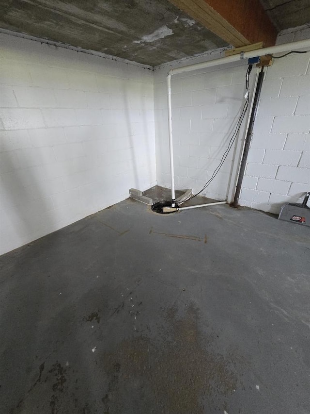 unfinished below grade area featuring concrete block wall