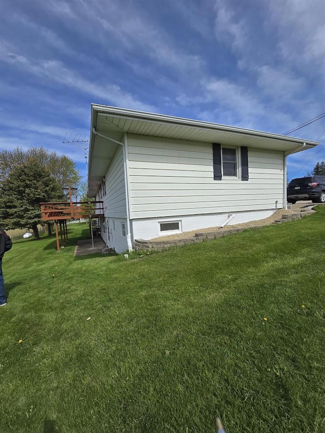 view of side of property with a deck and a lawn