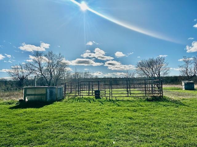view of yard featuring fence and a rural view