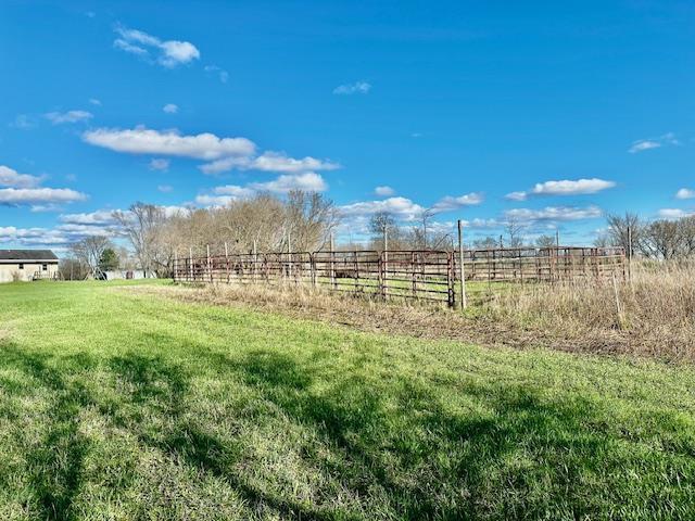 view of yard with a rural view and fence
