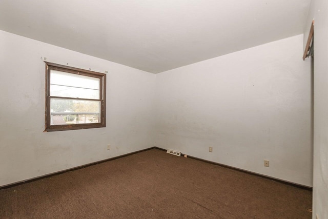 empty room with baseboards, visible vents, and carpet floors