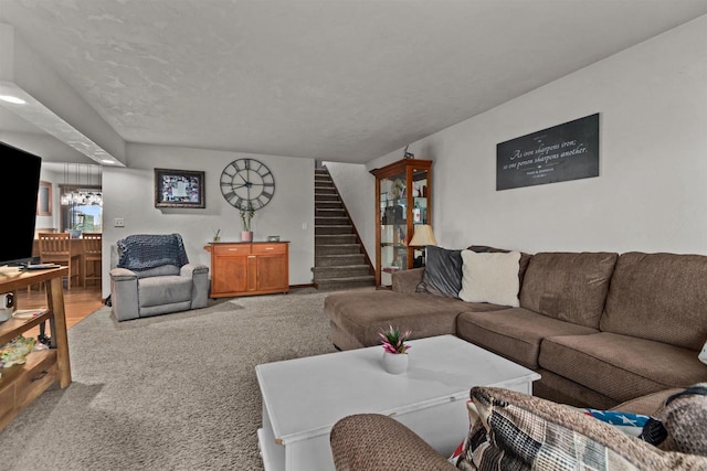 living area featuring stairs and carpet