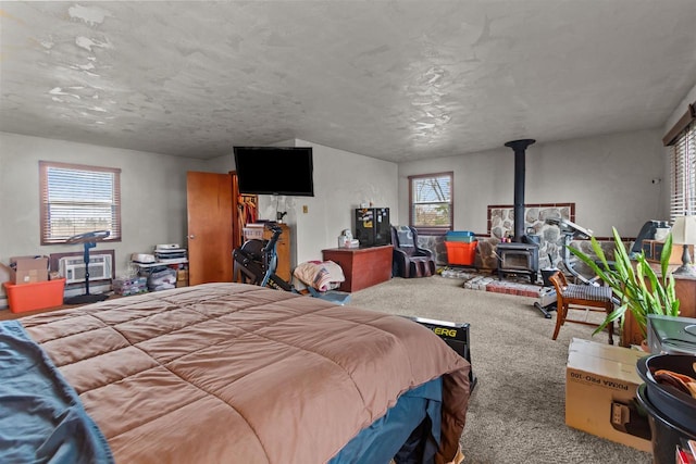 bedroom featuring carpet flooring and a wood stove