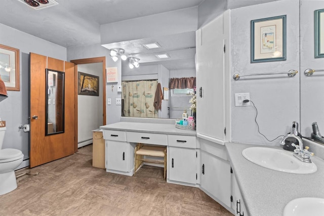 bathroom with a sink, toilet, a shower with curtain, and a baseboard heating unit