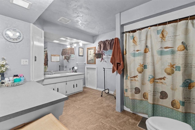 bathroom featuring curtained shower, vanity, and toilet