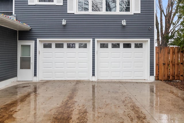 garage featuring fence and driveway