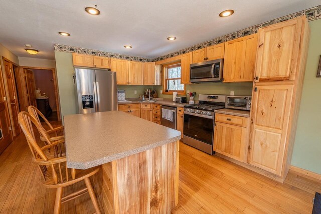 9327 Strong Rd, Argonne, WI 54511 - kitchen with a sink, stainless steel appliances, a toaster, light wood finished floors, and light brown cabinets