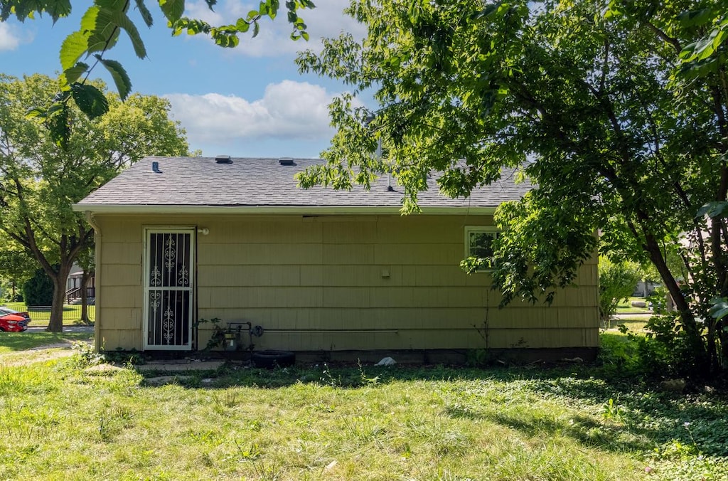 5750 N 62nd St, Milwaukee, WI 53218 - rear view of property featuring a lawn and roof with shingles