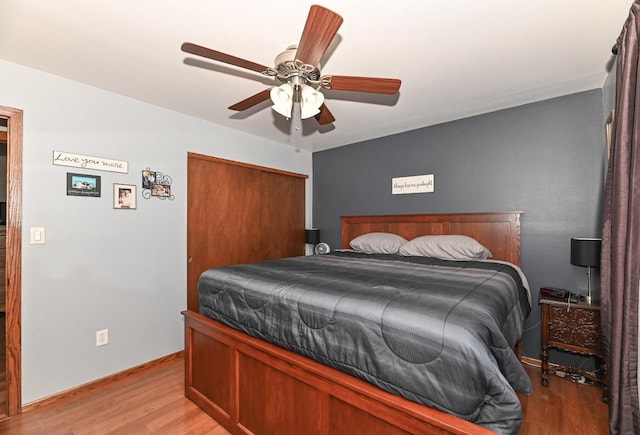 bedroom featuring light wood-style flooring, a closet, a ceiling fan, and baseboards
