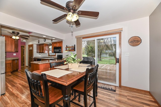 dining area featuring ceiling fan, baseboards, and wood finished floors