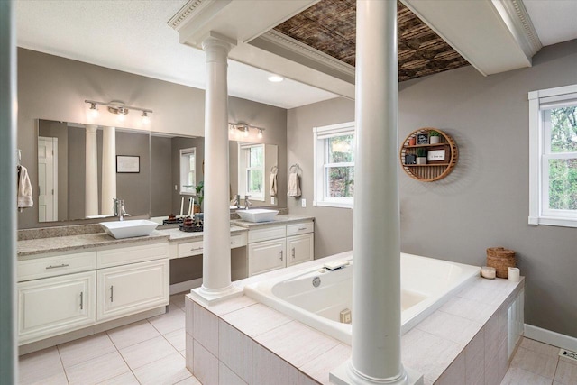 1218 Red Cedar Ct, Onalaska, WI 54650 - bathroom featuring a sink, two vanities, ornate columns, and a bath