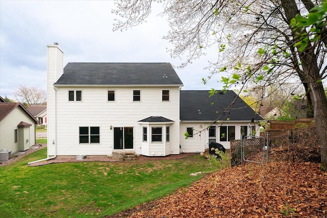 1218 Red Cedar Ct, Onalaska, WI 54650 - back of property featuring a gate, fence, a chimney, a lawn, and a shingled roof