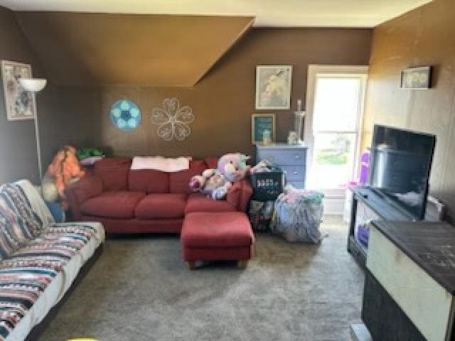 living area with vaulted ceiling and carpet floors