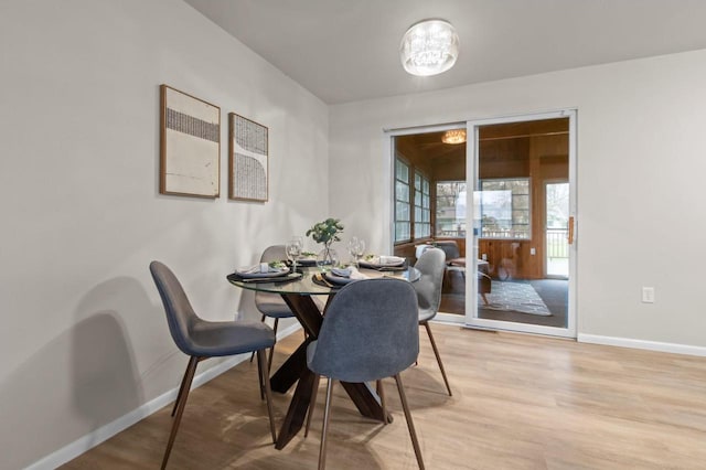 dining area with baseboards and light wood-style floors