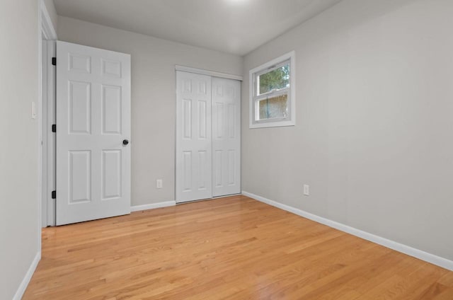 unfurnished bedroom with baseboards and light wood-type flooring