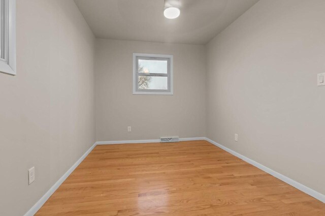 unfurnished room with light wood-type flooring, baseboards, and visible vents