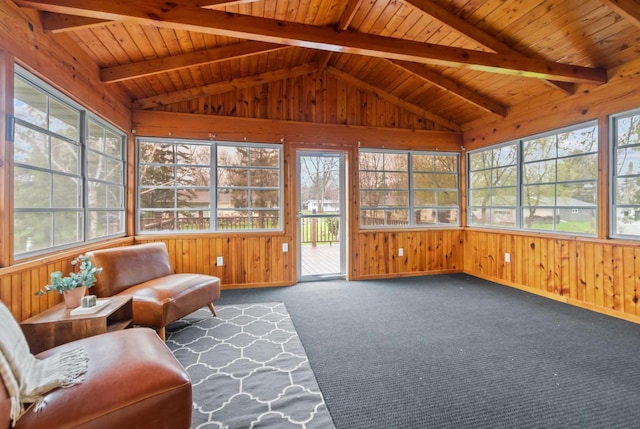 sunroom with wooden walls, carpet floors, baseboards, and vaulted ceiling with beams