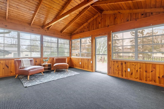 sunroom with carpet flooring, plenty of natural light, wooden walls, and lofted ceiling with beams