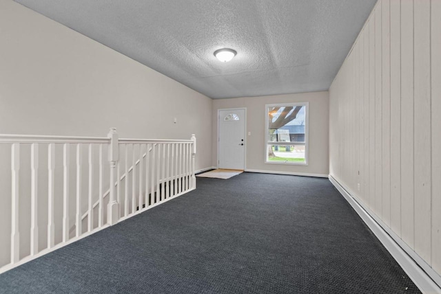 unfurnished room with dark colored carpet, a textured ceiling, and baseboard heating