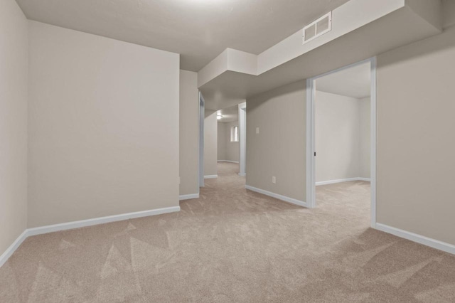 carpeted spare room featuring baseboards and visible vents