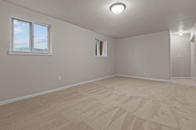 unfurnished room featuring baseboards and light colored carpet