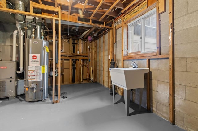 basement featuring concrete block wall and gas water heater