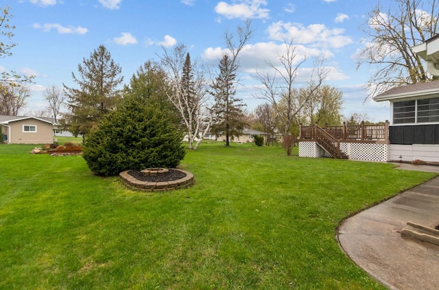 view of yard featuring stairs, a wooden deck, and a fire pit