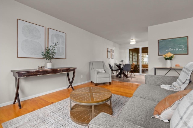 living area with baseboards and wood finished floors