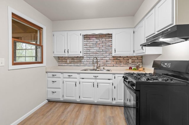 kitchen with under cabinet range hood, black gas stove, a sink, and light countertops