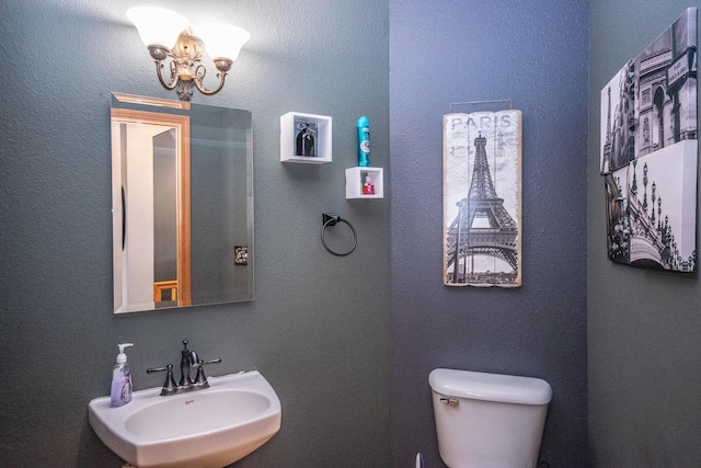 2704 Kettle Ct, West Bend, WI 53090 - bathroom featuring a sink, an inviting chandelier, and toilet